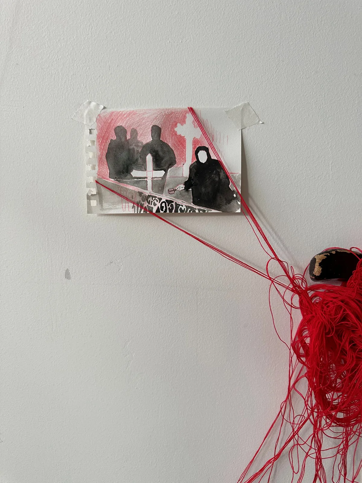 Mourning drawing in red and black ink tethered by red wool threads to the walking stick