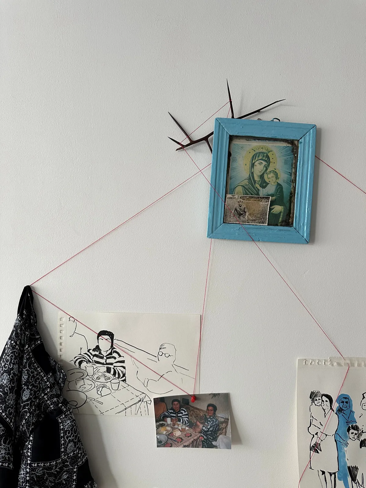 Diagonal red threads linking the Orthodox icon to the family table drawing and robe